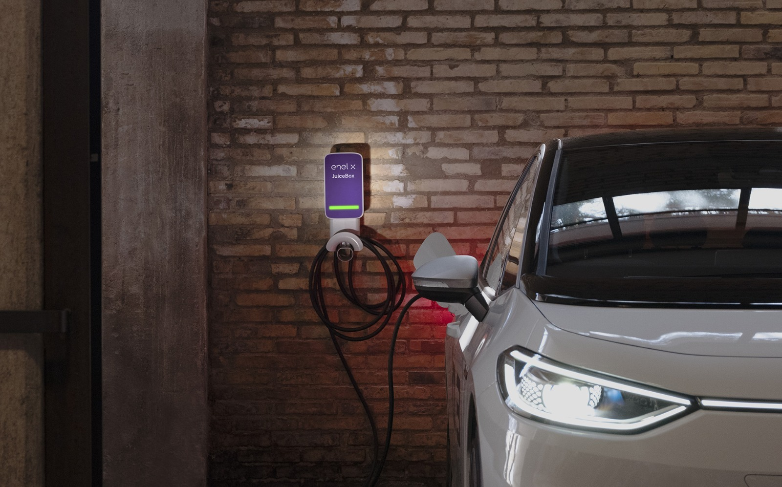 Carregador veicular instalado em garagem, junto a um carro elétrico
