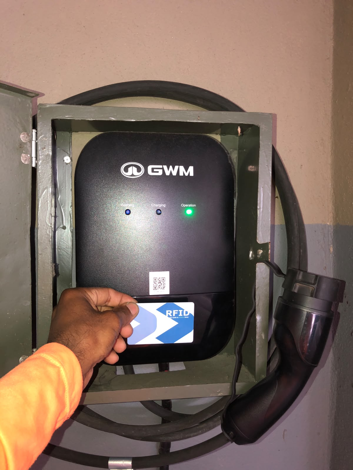 Carregador GWM instalado em quadro metálico, com cartão RFID em uso